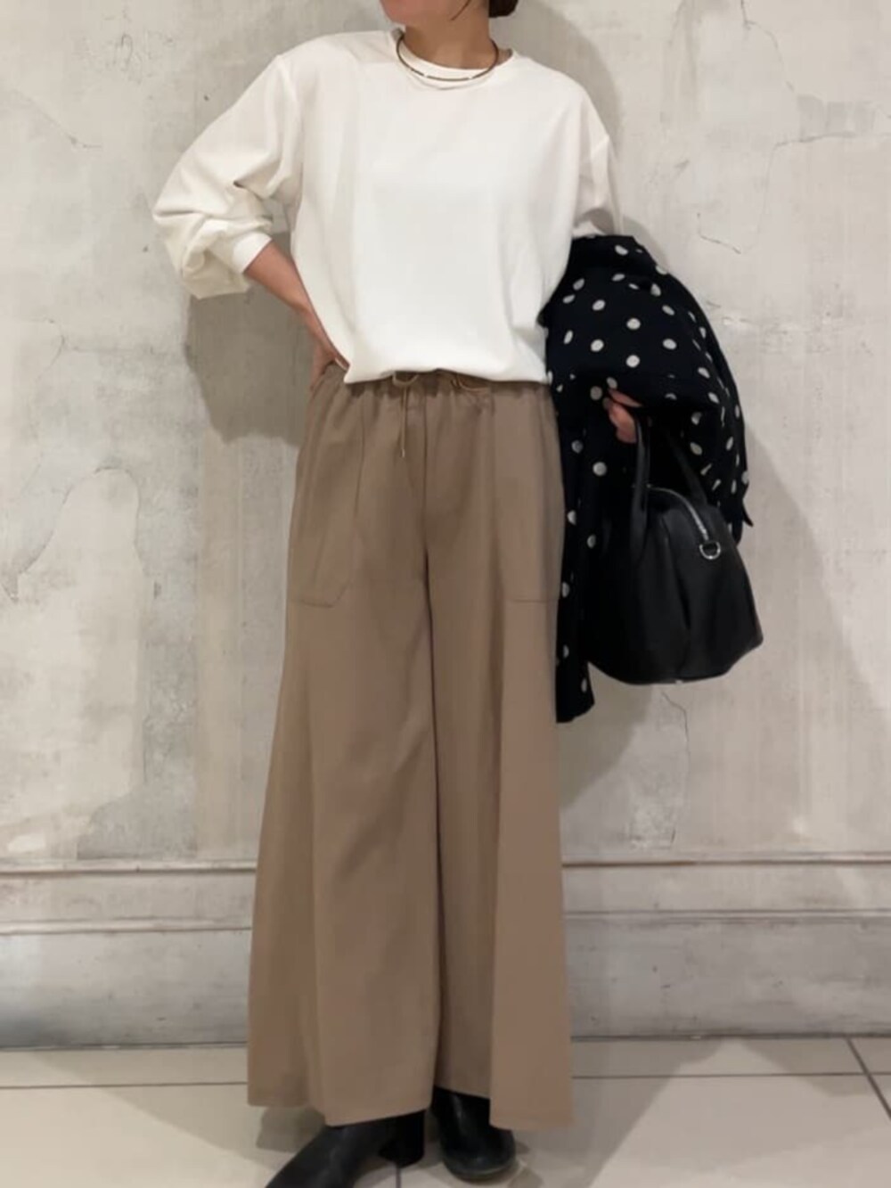 ホワイト系のシャツ/ブラウス、ブラック系のその他アウター、ベージュ系のその他パンツを着用したレディースの冬コーディネートの6枚目の写真