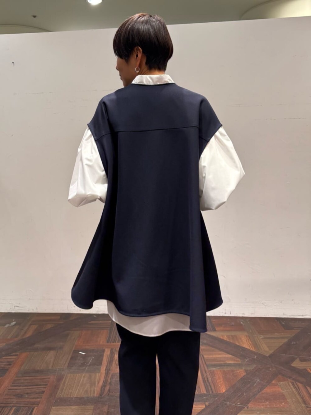 ブラック系のボストンバッグ、ブルー系のベスト、ホワイト系のシャツ/ブラウスを着用したレディースの冬コーディネートの5枚目の写真