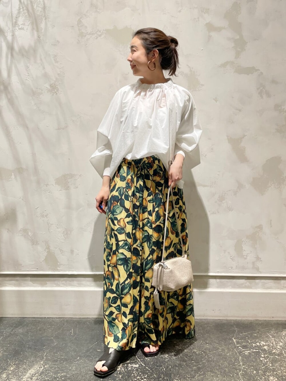 ホワイト系のシャツ/ブラウス、イエロー系のその他パンツ、ベージュ系のトートバッグを着用したレディースの春コーディネートの4枚目の写真