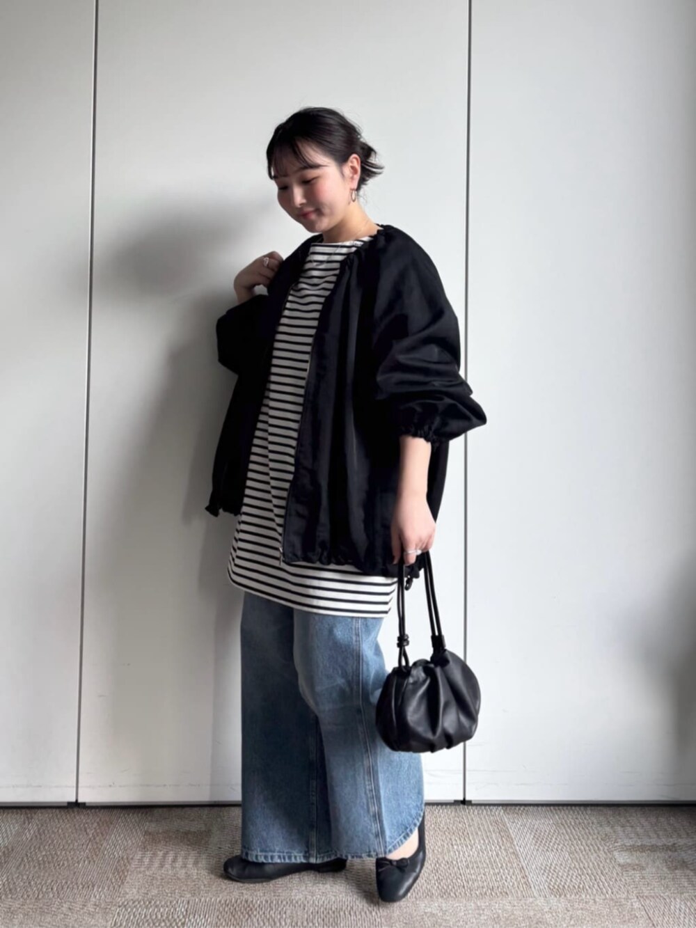 ブラック系のノーカラージャケット、ブルー系のその他パンツを着用したレディースの冬コーディネートの2枚目の写真