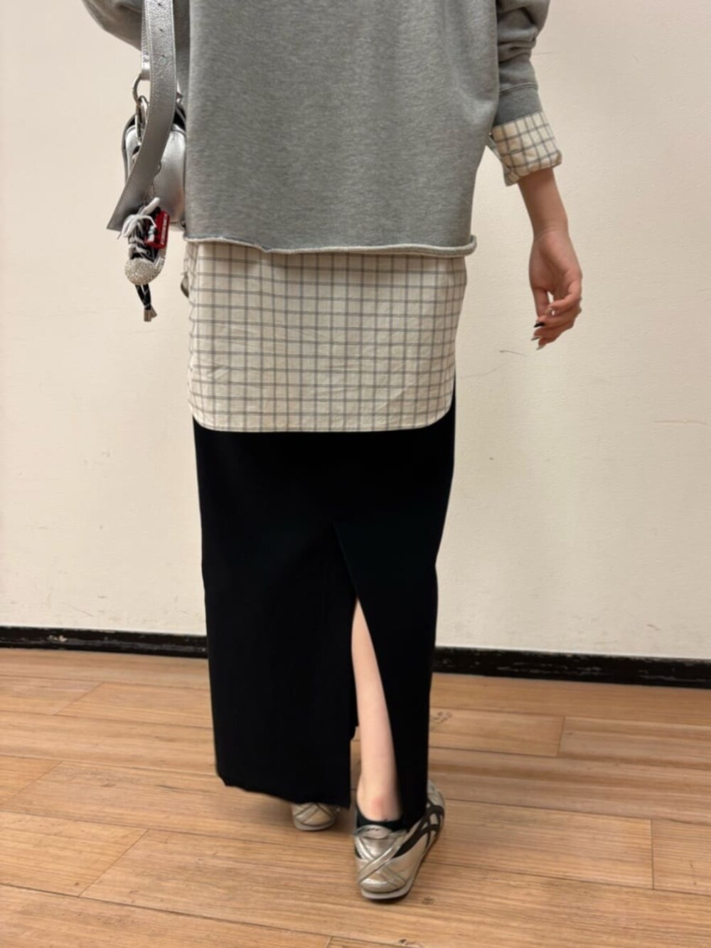 シルバー系のショルダーバッグ、ホワイト系のシャツ/ブラウス、ブラック系のスカートを着用したレディースの冬コーディネートの9枚目の写真