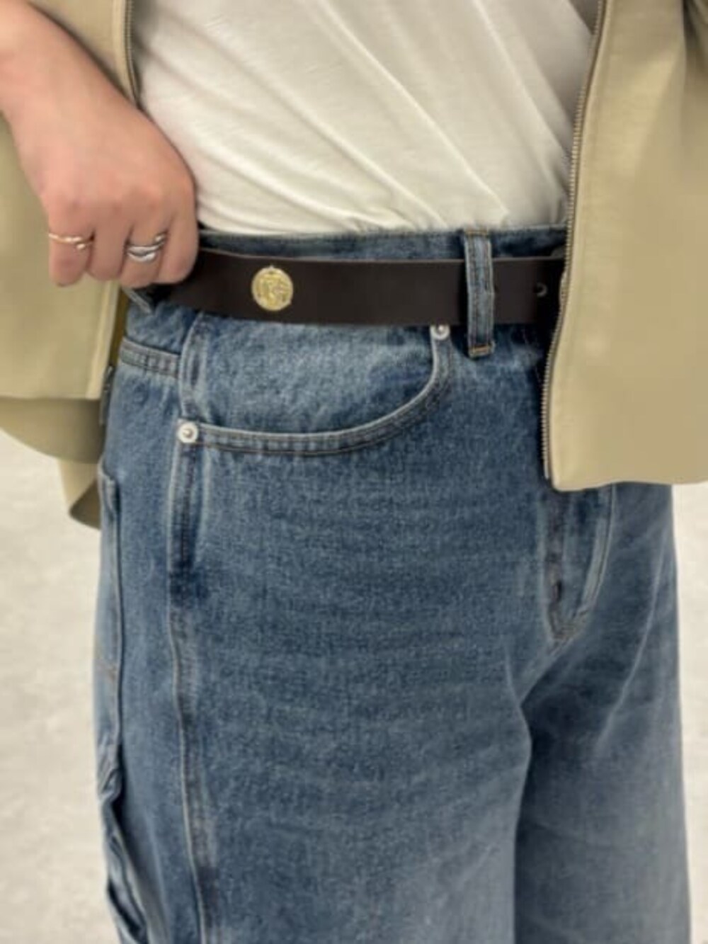 ベージュ系のカーディガン/ボレロ、ブルー系のその他パンツ、ブラウン系のベルトを着用したレディースの冬コーディネートの8枚目の写真