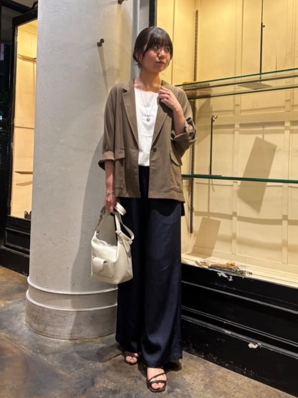 ブルー系のその他パンツ、ホワイト系のトートバッグ、ブラウン系のテーラードジャケットを着用したレディースの春コーディネートの2枚目の写真