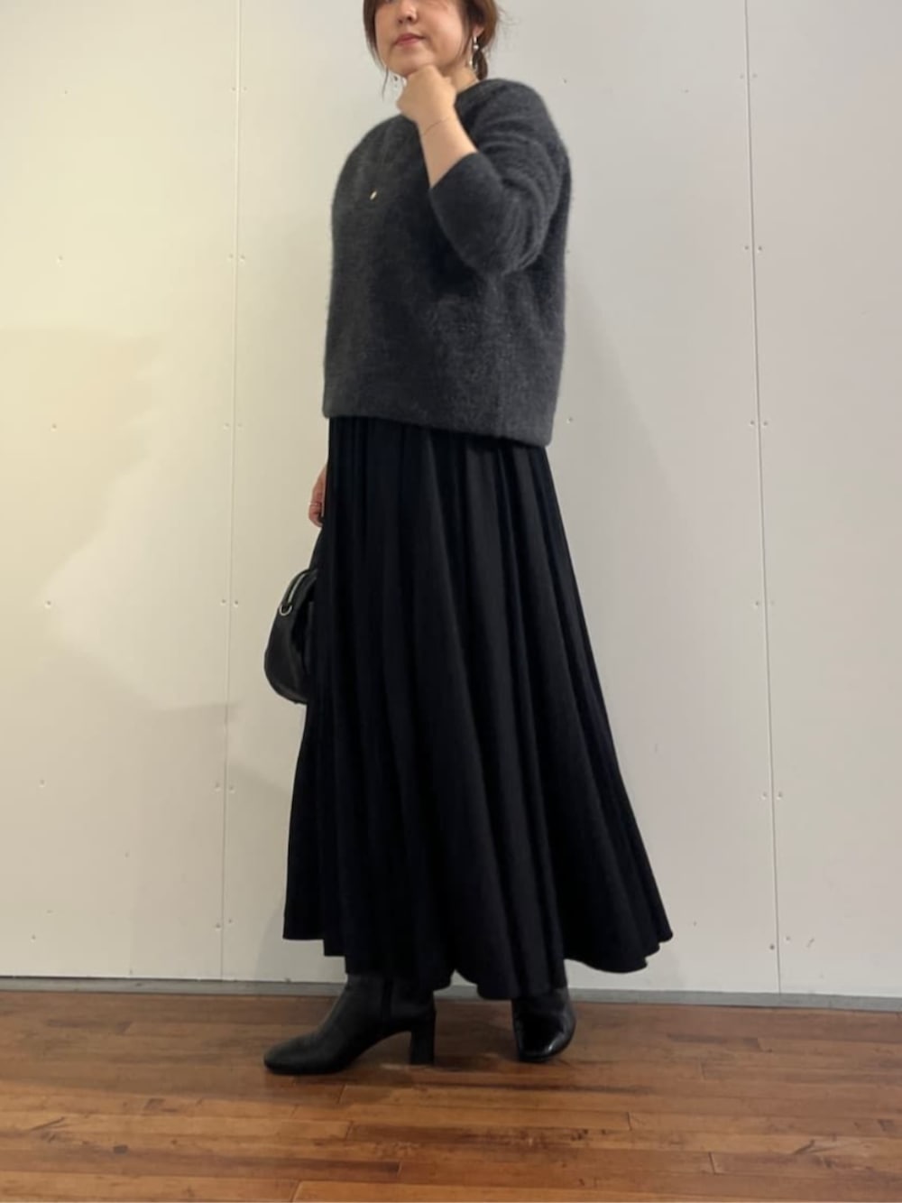 ブラック系のスカート、グレー系のニット/セーターを着用したレディースの秋コーディネートの4枚目の写真