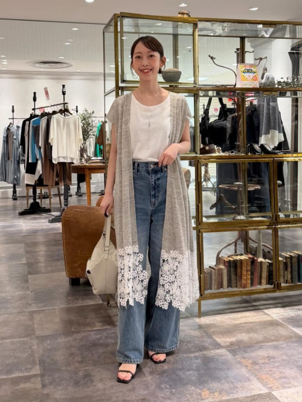 ブルー系のその他パンツ、ホワイト系のキャミソール、グレー系のカーディガン/ボレロを着用したレディースの春コーディネートの2枚目の写真