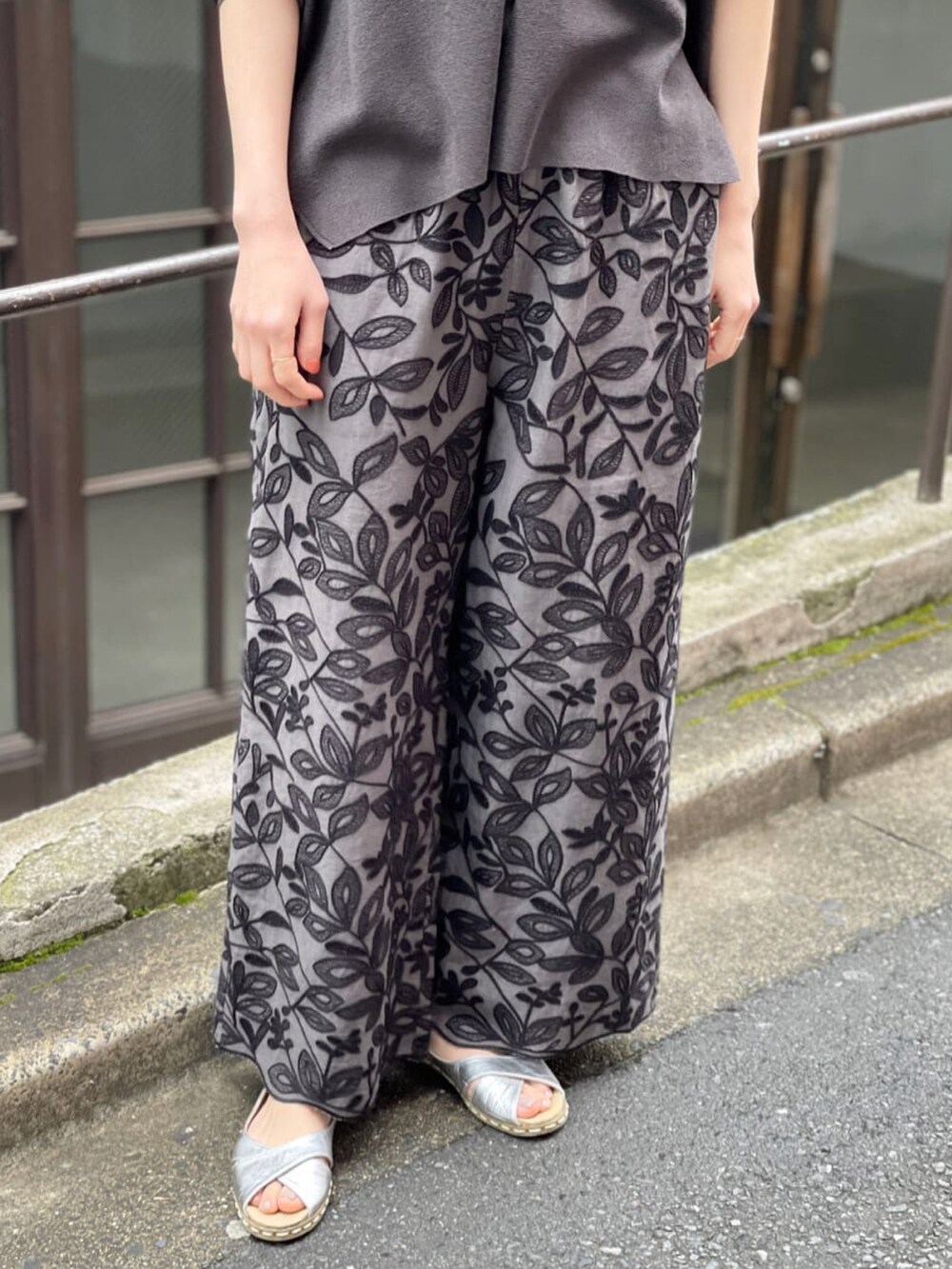 ブラック系のカーディガン/ボレロ、グレー系のその他パンツ、シルバー系のサンダルを着用したレディースの春コーディネートの3枚目の写真