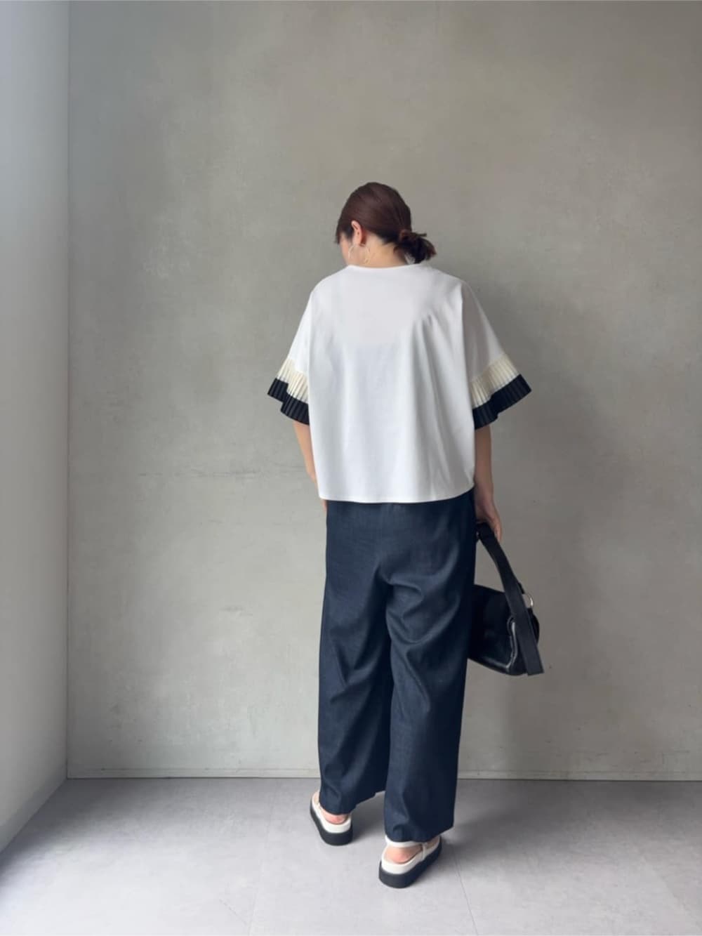 ブルー系のその他パンツ、ブラック系のショルダーバッグ、ホワイト系のサンダルを着用したレディースの春コーディネートの4枚目の写真