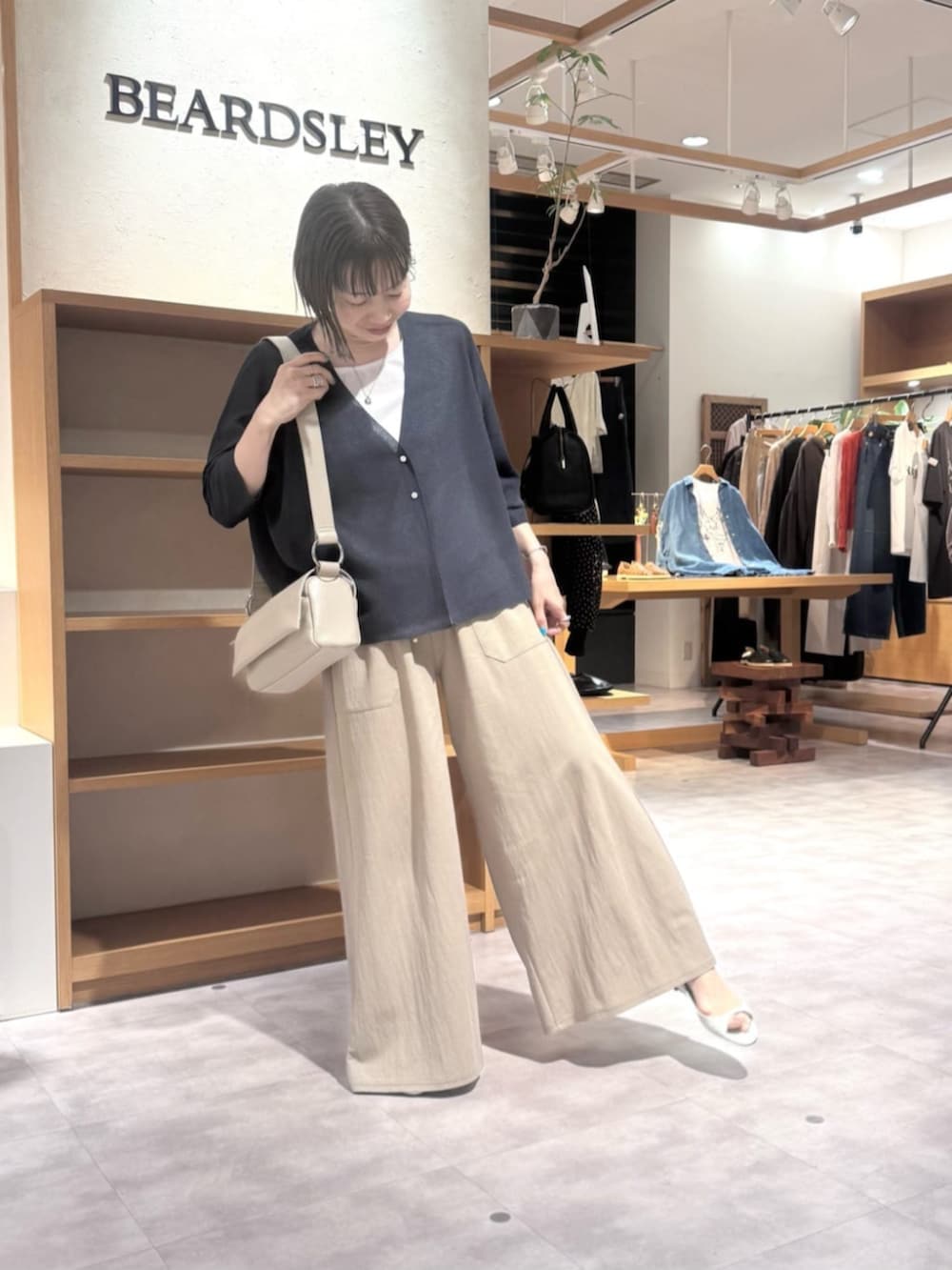 ベージュ系のその他パンツ、ベージュ系のショルダーバッグ、ブルー系のカーディガン/ボレロを着用したレディースの春コーディネートの8枚目の写真