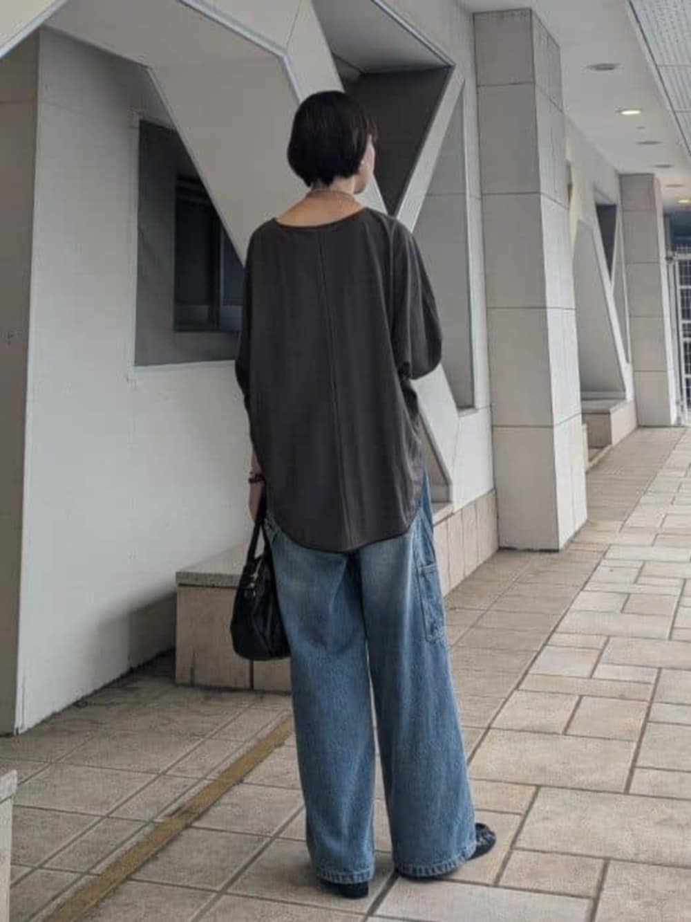 ブラック系のボストンバッグ、ブルー系のその他パンツ、ブラウン系のTシャツ/カットソーを着用したレディースの夏コーディネートの6枚目の写真