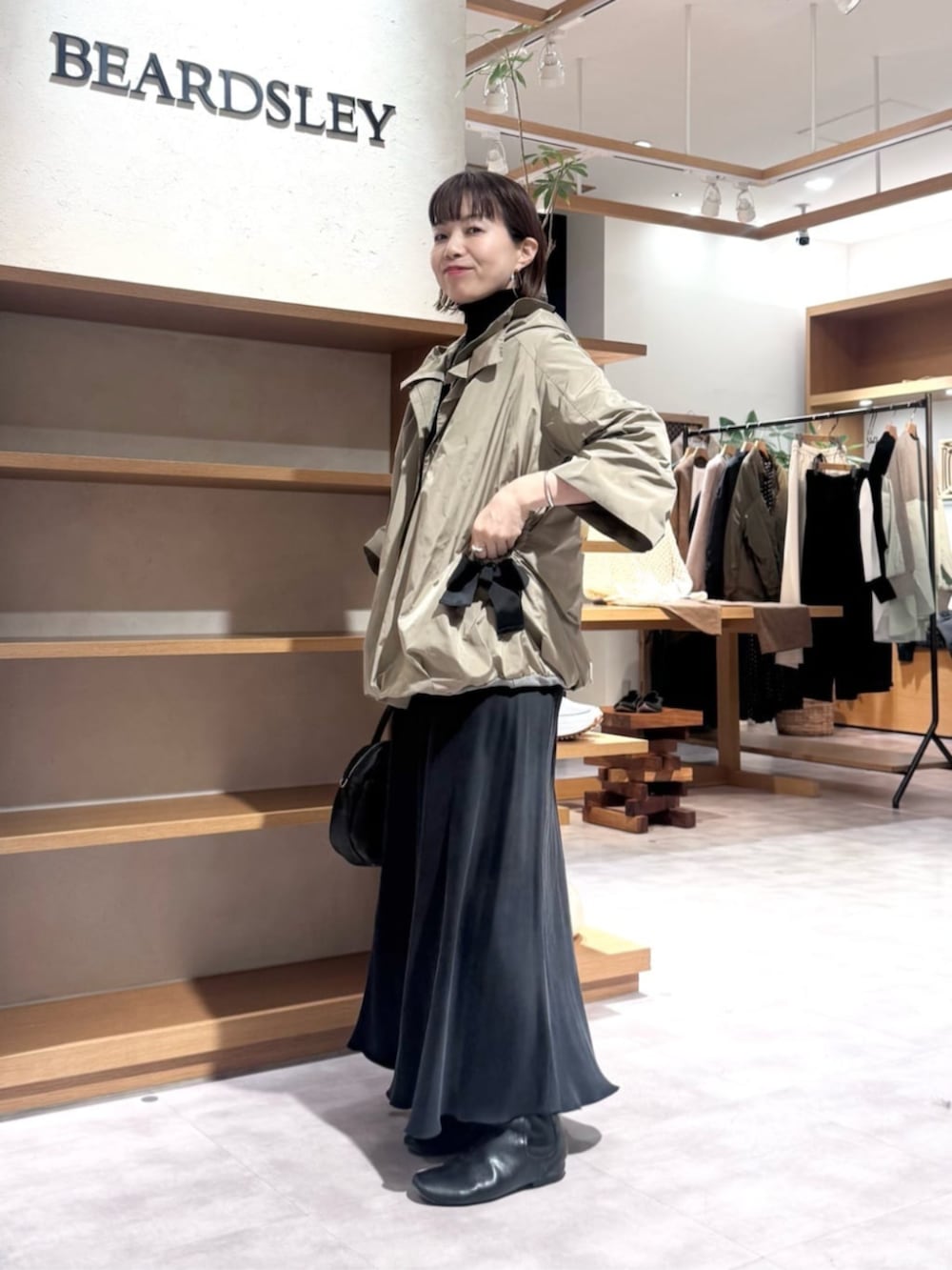 ブラック系のスカート、ブラウン系のブルゾンを着用したレディースの冬コーディネートの3枚目の写真