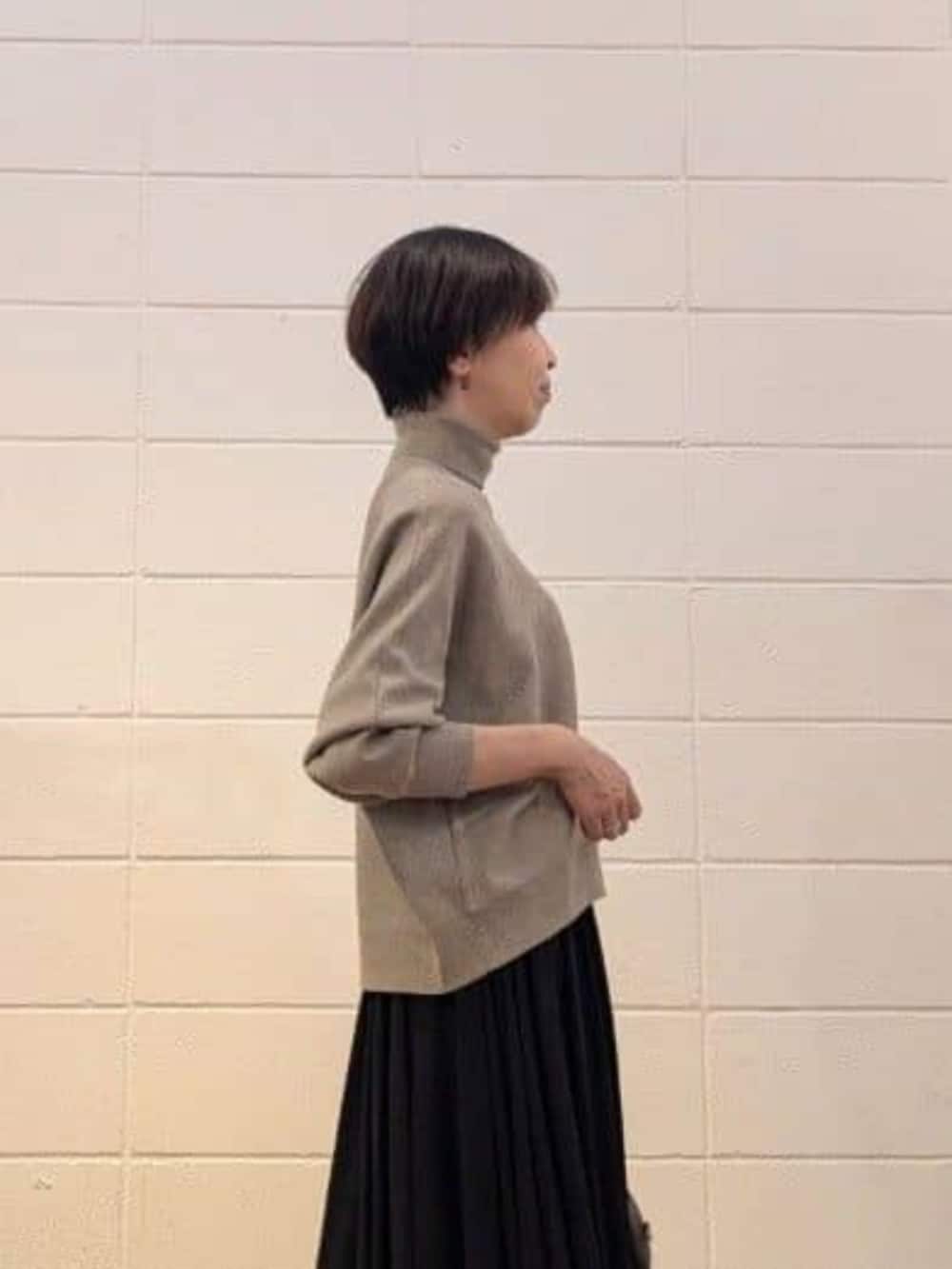 ブラウン系のトートバッグ、ブラック系のスカート、ブラウン系のニット/セーターを着用したレディースの秋コーディネートの3枚目の写真