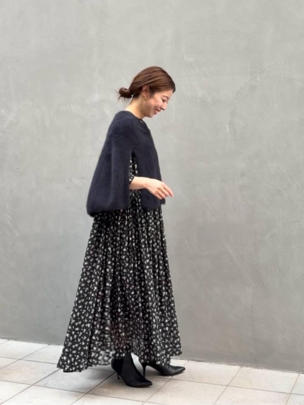 ブラック系のニット/セーター、ブラック系のトートバッグ、ブラック系のワンピースを着用したレディースの夏コーディネートの8枚目の写真