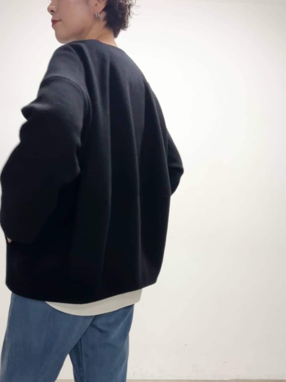 ブルー系のデニムパンツ、ブルー系のノーカラーコート、ホワイト系のシャツ/ブラウスを着用したレディースの冬コーディネートの5枚目の写真