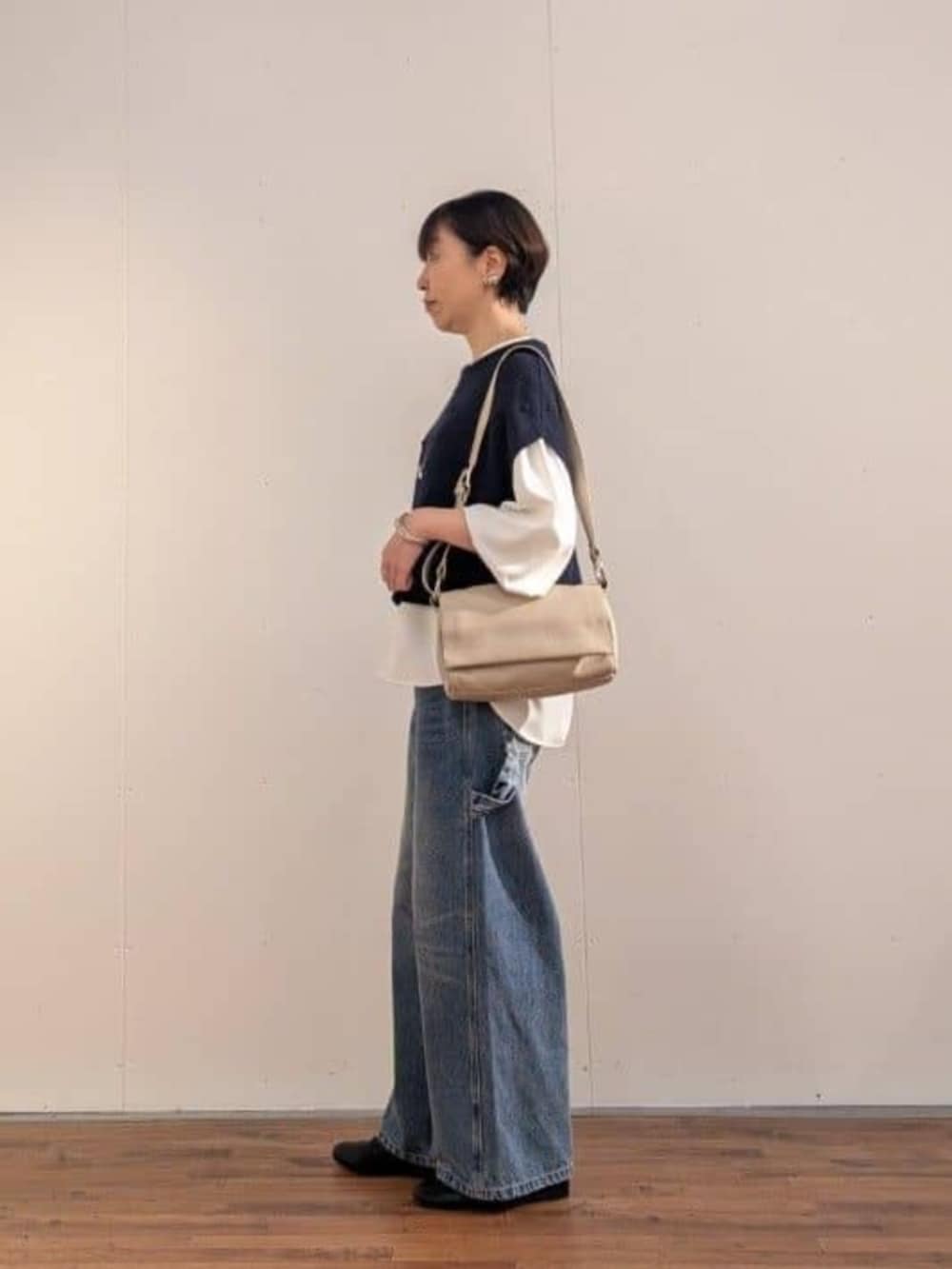 ブルー系のデニムパンツ、ホワイト系のシャツ/ブラウス、ブルー系のベストを着用したレディースの秋コーディネートの3枚目の写真