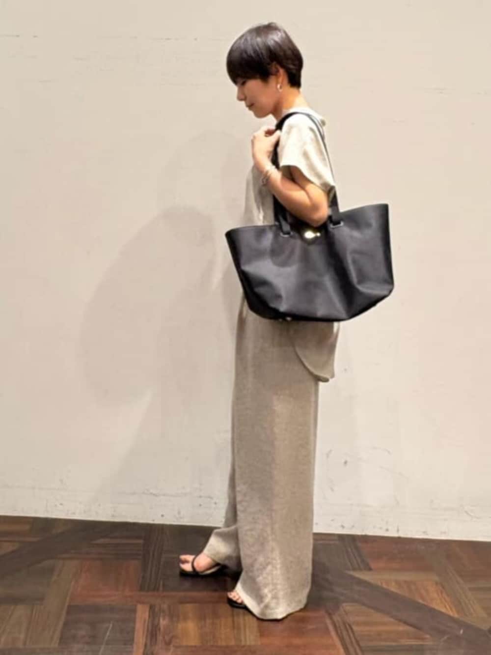 ブラック系のトートバッグ、ベージュ系のその他パンツ、ベージュ系のシャツ/ブラウスを着用したレディースの春コーディネートの2枚目の写真