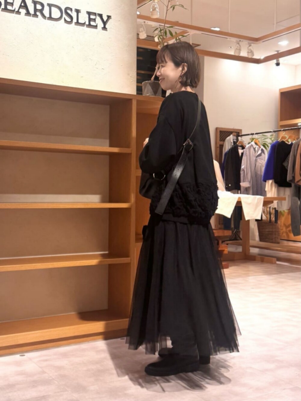 ブラック系のTシャツ/カットソー、ブラック系のスカートを着用したレディースの秋コーディネートの6枚目の写真