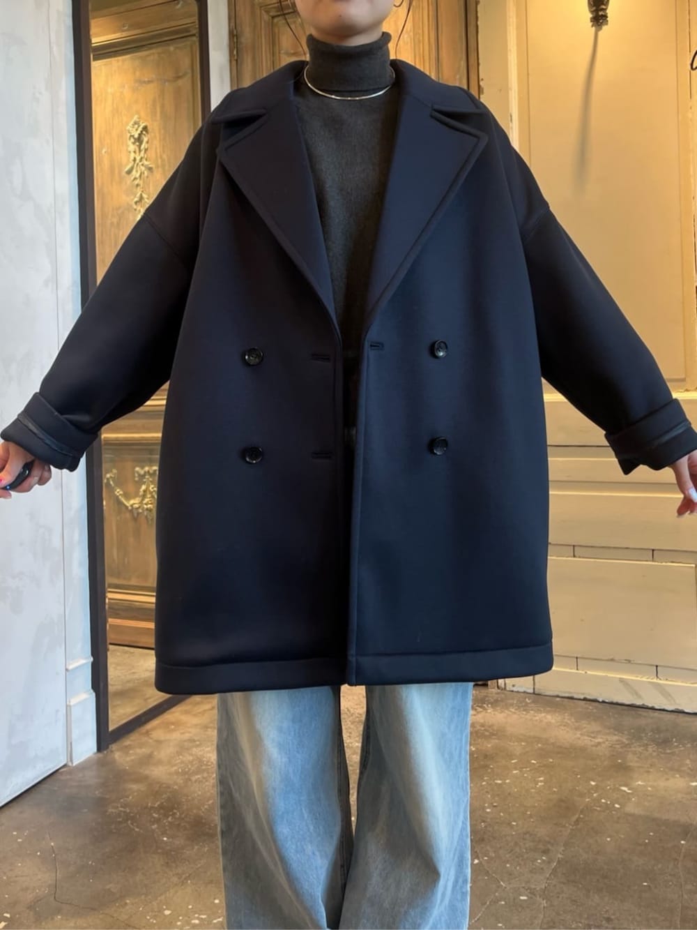 グレー系のニット/セーター、ブルー系のピーコートを着用したレディースの冬コーディネートの5枚目の写真