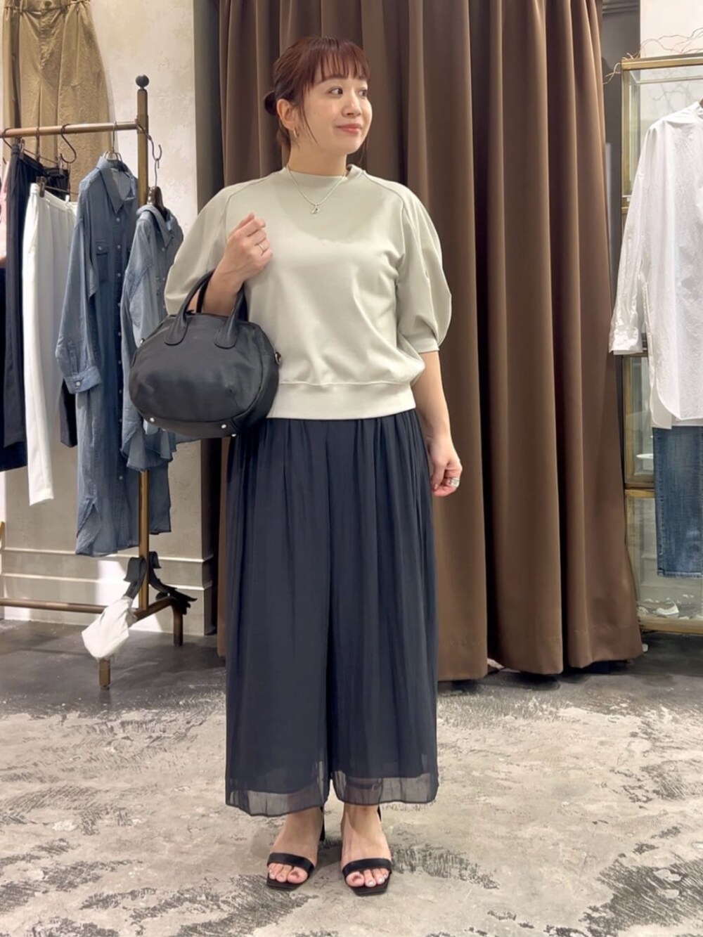 ブラック系のボストンバッグ、ブラック系のその他パンツ、グレー系のTシャツ/カットソーを着用したレディースの春コーディネートの3枚目の写真