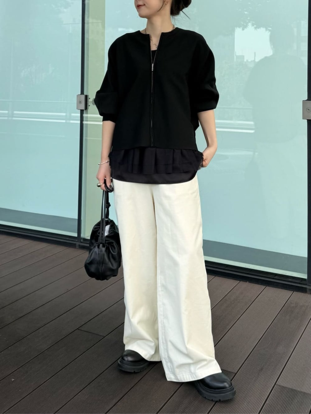 ブラック系のカーディガン/ボレロ、ブラック系のタンクトップ、ホワイト系のその他パンツを着用したレディースの冬コーディネートの3枚目の写真