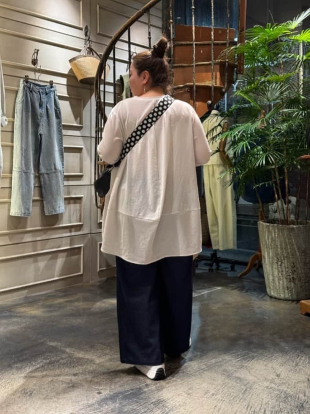 ホワイト系のTシャツ/カットソー、ブラック系のボストンバッグ、ホワイト系のスニーカーを着用したレディースの春コーディネートの4枚目の写真