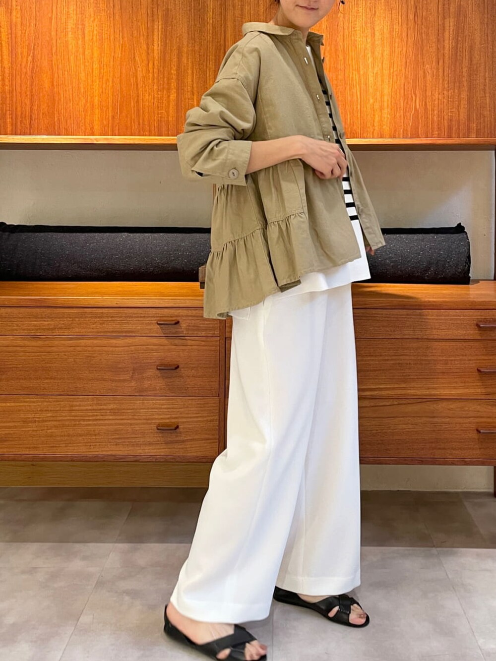 ベージュ系のシャツ/ブラウス、ブラック系のニット/セーター、ホワイト系のその他パンツを着用したレディースの春コーディネートの2枚目の写真