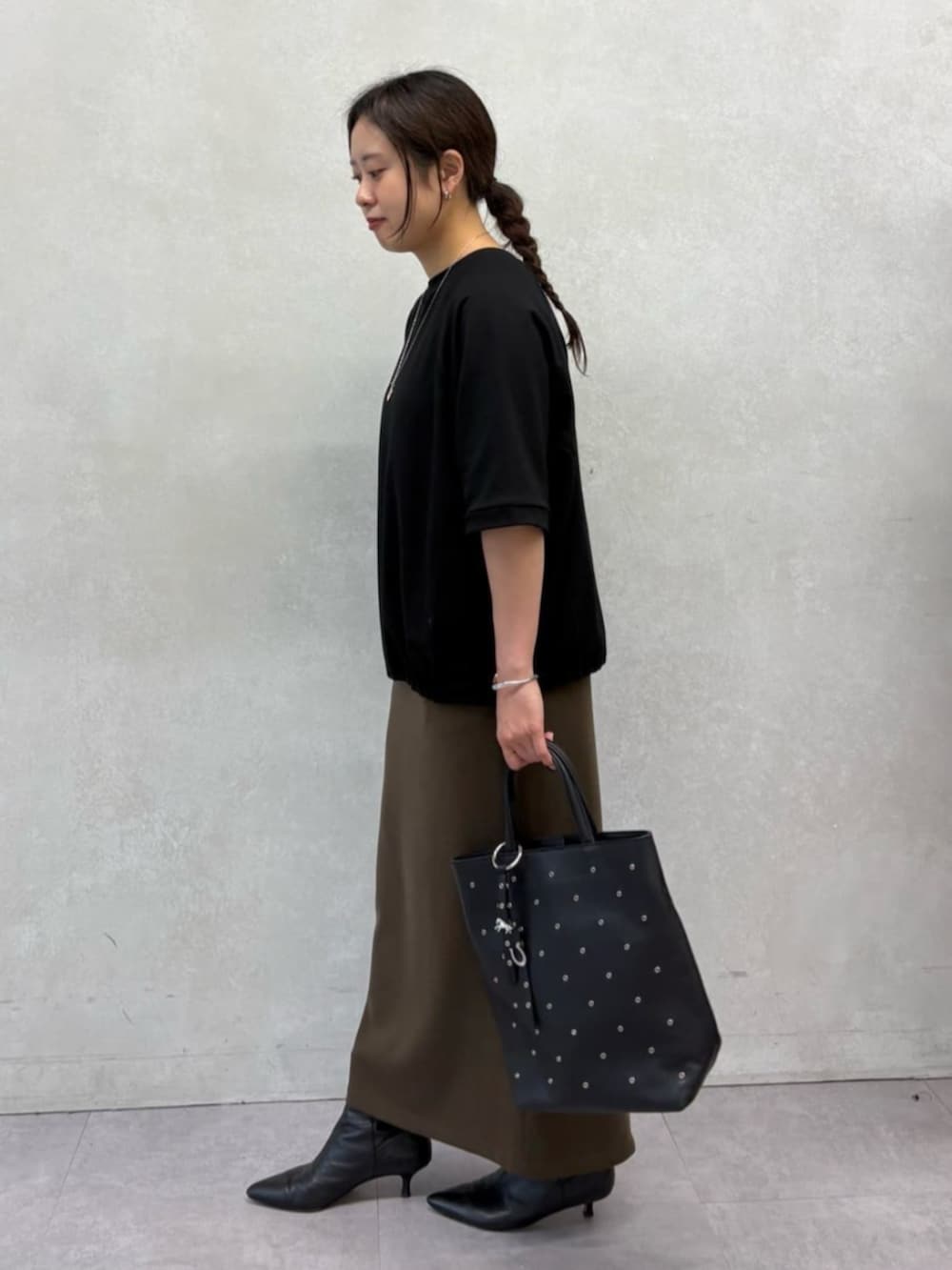 ブラック系のトートバッグ、ブラック系のTシャツ/カットソー、ブラウン系のスカートを着用したレディースの夏コーディネートの2枚目の写真