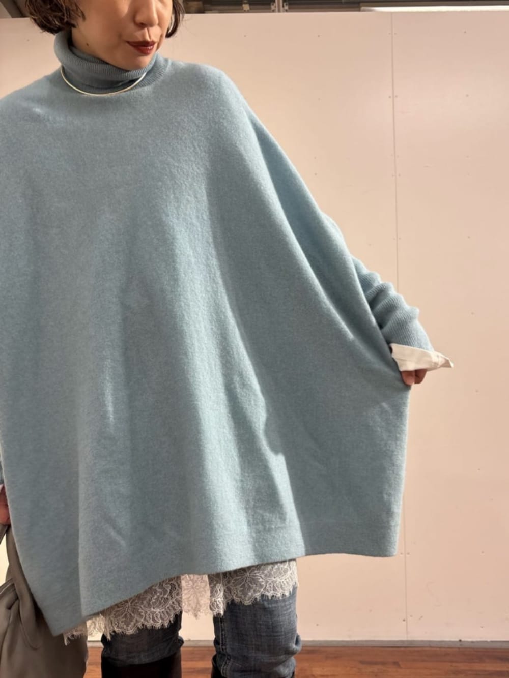 ブルー系のデニムパンツ、グレー系のトートバッグ、ホワイト系のTシャツ/カットソーを着用したレディースの秋コーディネートの2枚目の写真
