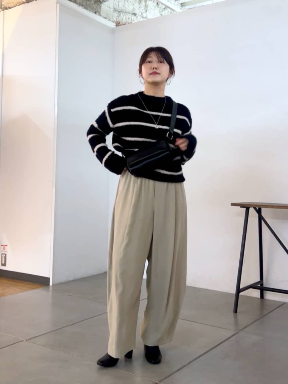 ブラック系のショルダーバッグ、グレー系のその他パンツ、ブラック系のニット/セーターを着用したレディースの秋コーディネートの3枚目の写真