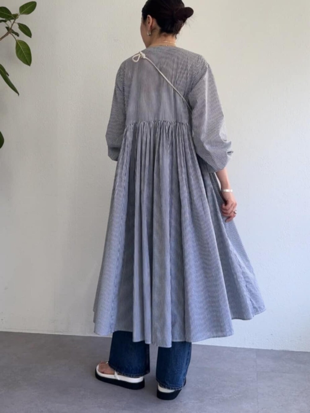 ホワイト系のショルダーバッグ、ブルー系のワンピースを着用したレディースの冬コーディネートの3枚目の写真