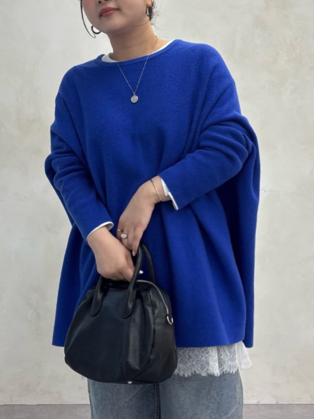 ブルー系のデニムパンツ、ブルー系のニット/セーター、ホワイト系のTシャツ/カットソーを着用したレディースの秋コーディネートの7枚目の写真