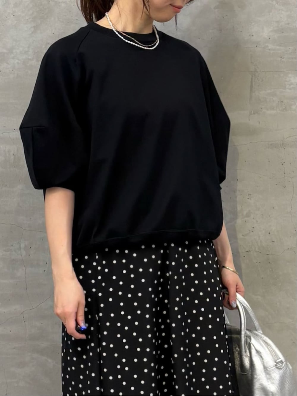 シルバー系のボストンバッグ、ブラック系のスカート、ブラック系のTシャツ/カットソーを着用したレディースの冬コーディネートの4枚目の写真