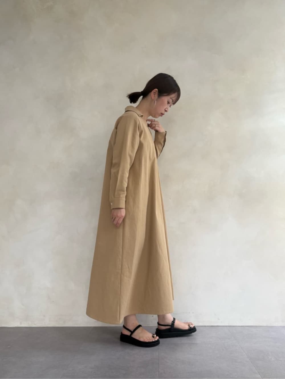 ブラック系のサンダル、ブラック系のショルダーバッグ、ベージュ系のワンピースを着用したレディースの春コーディネートの3枚目の写真