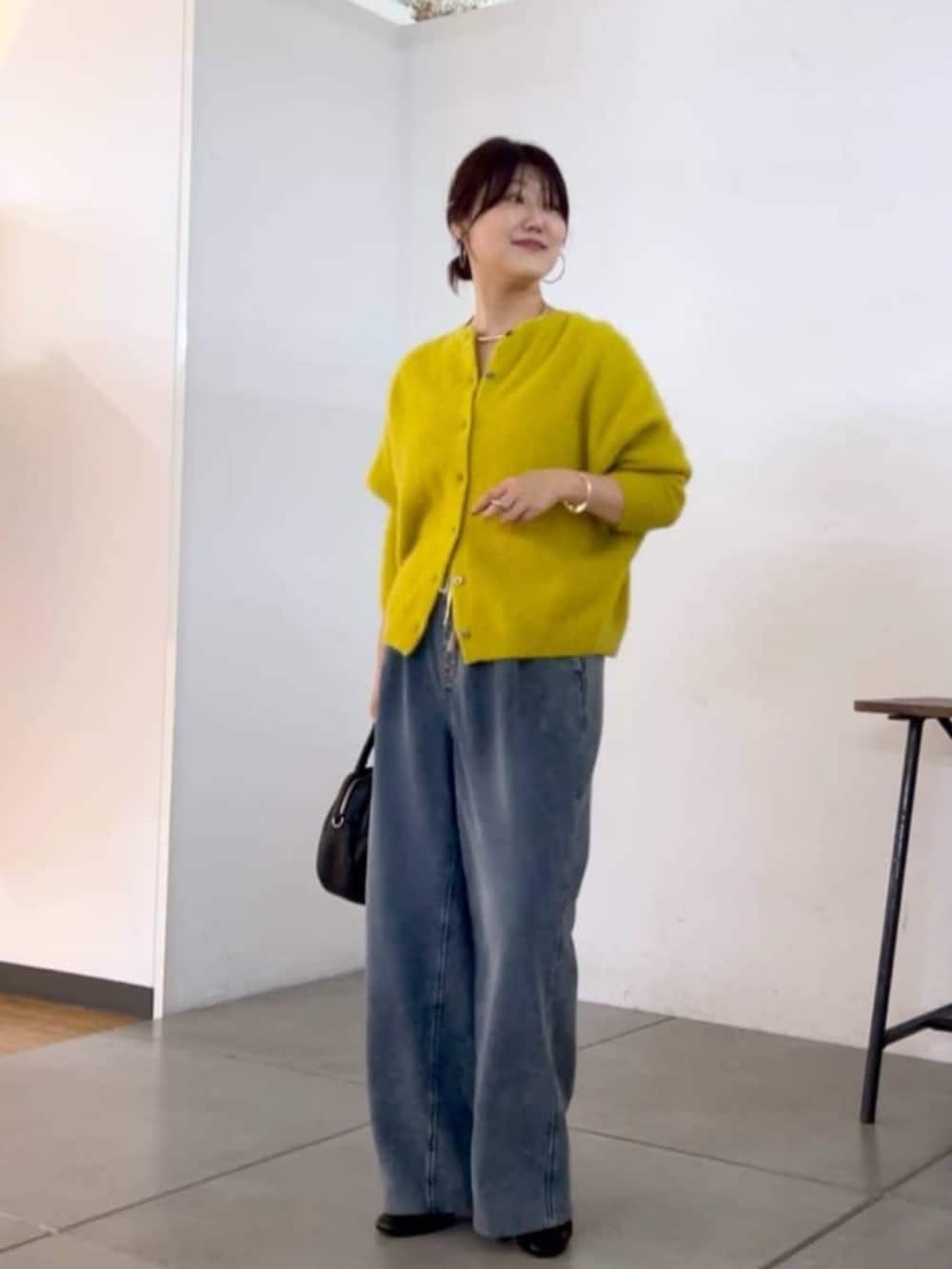 ブラック系のトートバッグ、イエロー系のニット/セーター、ブルー系のその他パンツを着用したレディースの秋コーディネートの9枚目の写真