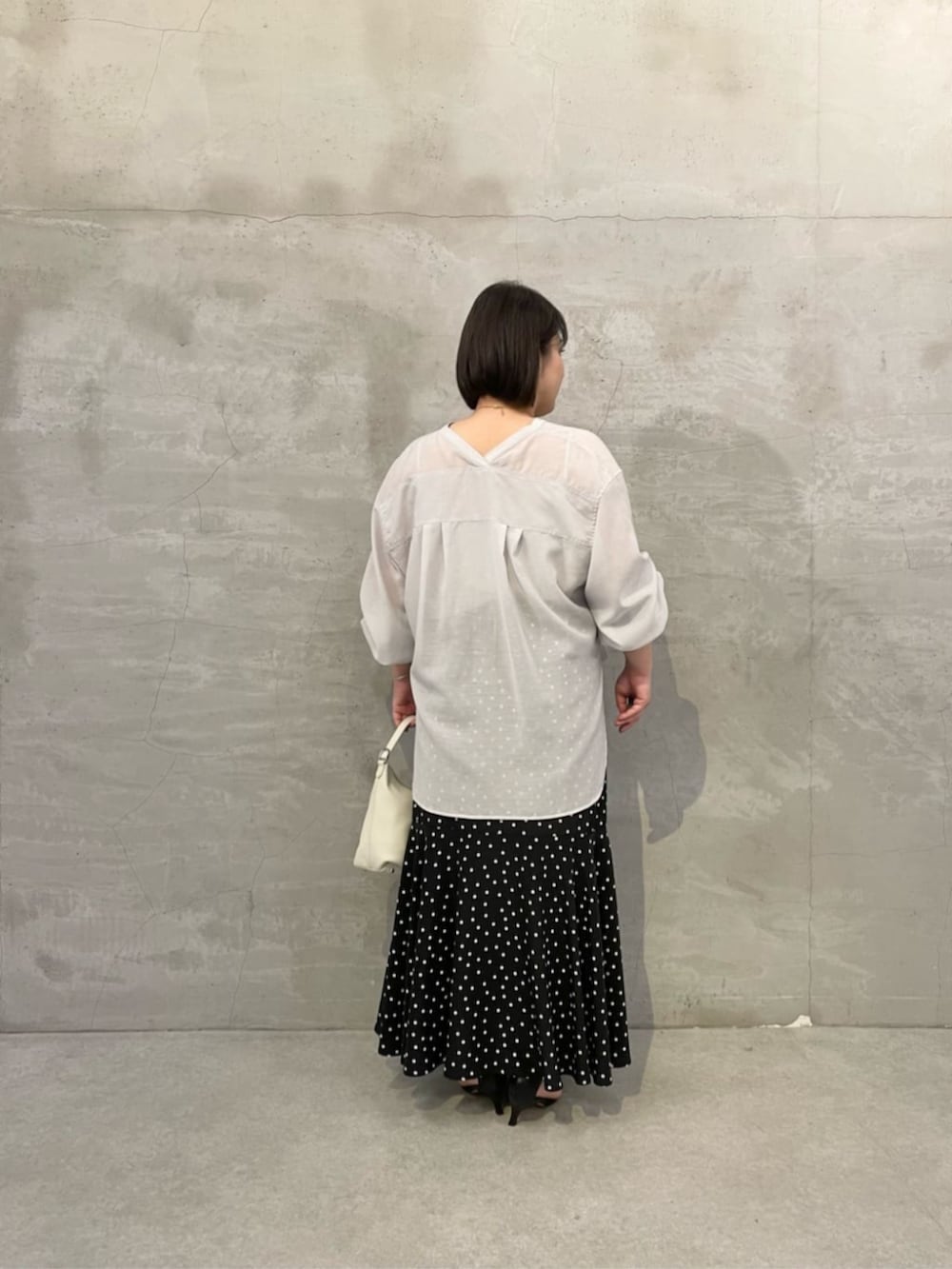 ブラック系のスカート、ホワイト系のトートバッグ、グレー系のシャツ/ブラウスを着用したレディースの冬コーディネートの3枚目の写真