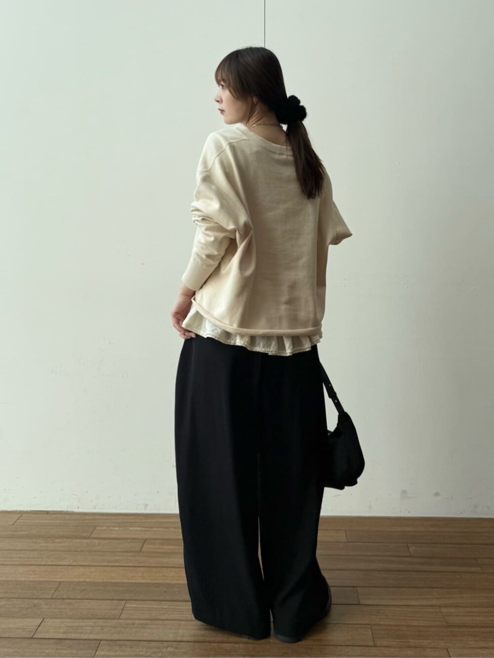 ブラック系のショルダーバッグ、ブラック系のその他パンツ、ホワイト系のキャミソールを着用したレディースの冬コーディネートの2枚目の写真