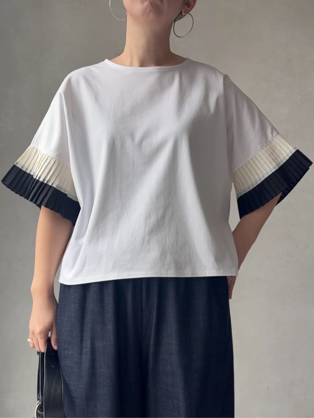 ブルー系のその他パンツ、ブラック系のショルダーバッグ、ホワイト系のサンダルを着用したレディースの春コーディネートの6枚目の写真