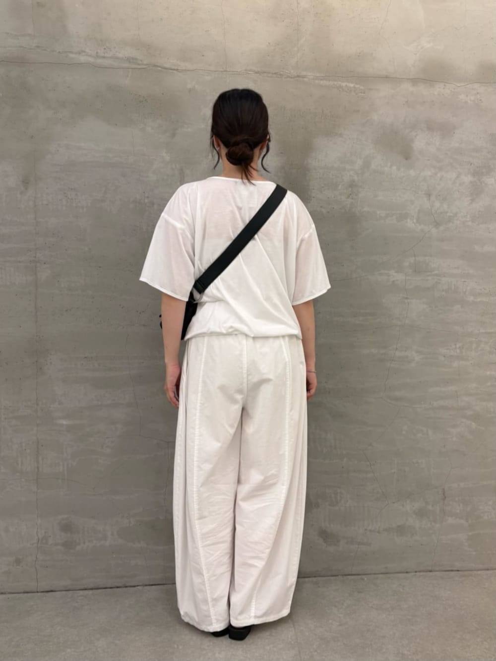ブラック系のショルダーバッグ、ホワイト系のTシャツ/カットソーを着用したレディースの春コーディネートの5枚目の写真
