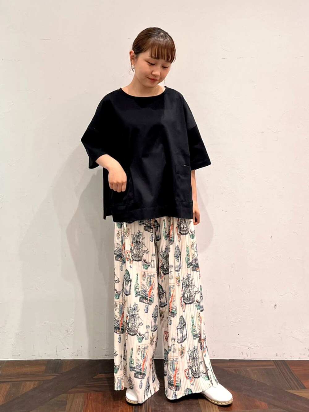 ブラック系のTシャツ/カットソー、ベージュ系のその他パンツ、ホワイト系のその他シューズを着用したレディースの春コーディネートの2枚目の写真