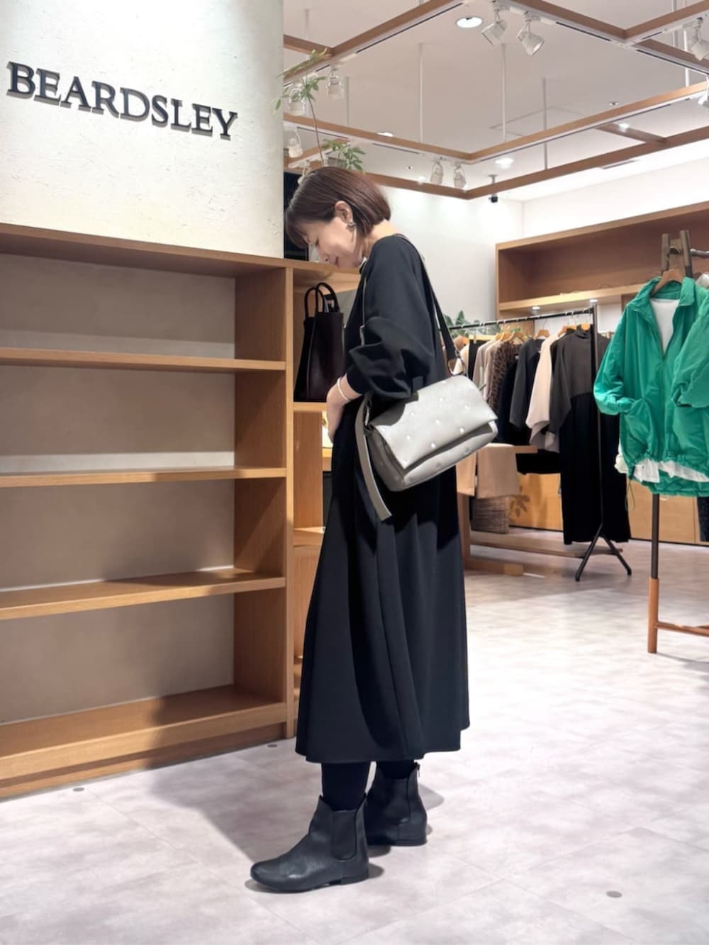 ブラック系のブーツ、ブラック系のワンピース、グレー系のショルダーバッグを着用したレディースの冬コーディネートの3枚目の写真