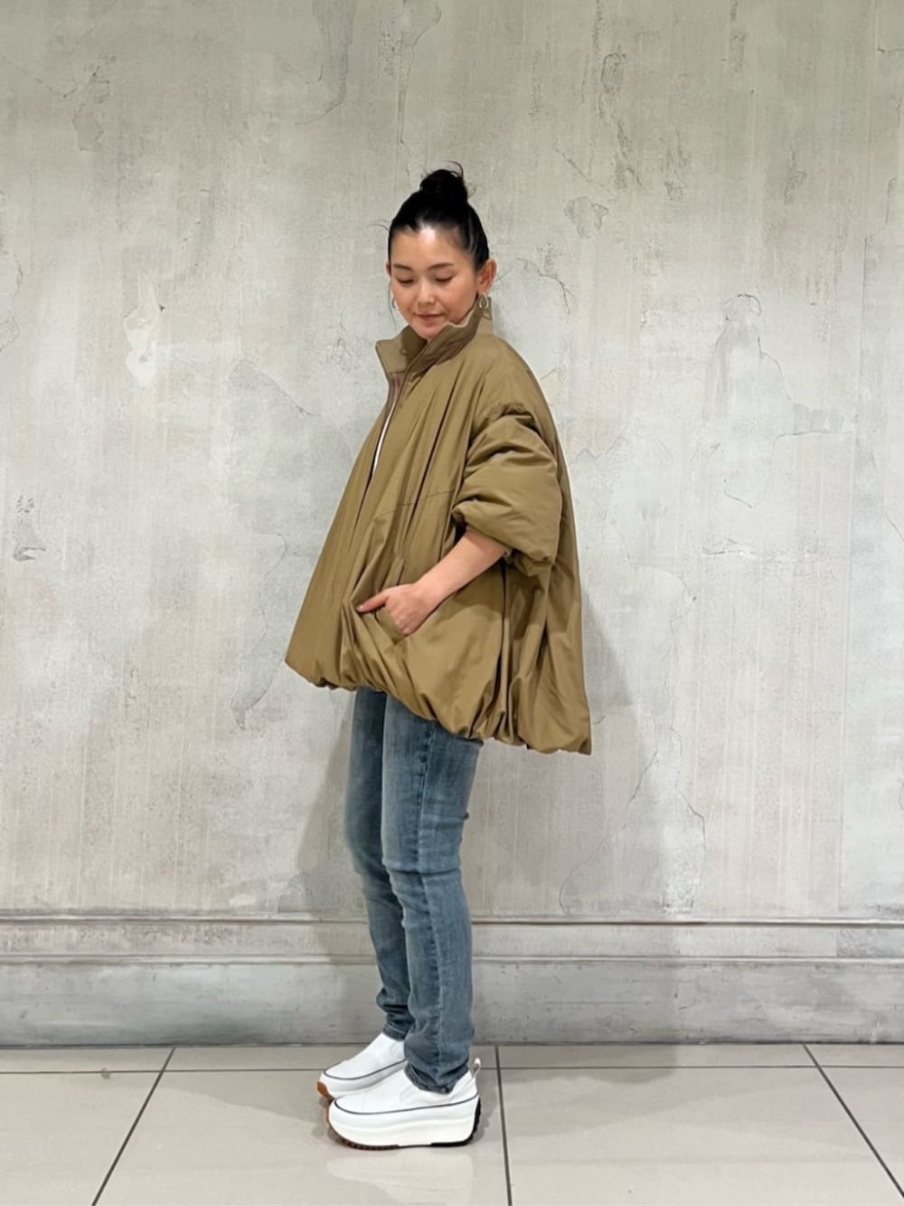 ホワイト系のスニーカー、ブルー系のデニムパンツ、イエロー系のその他アウターを着用したレディースの冬コーディネートの10枚目の写真