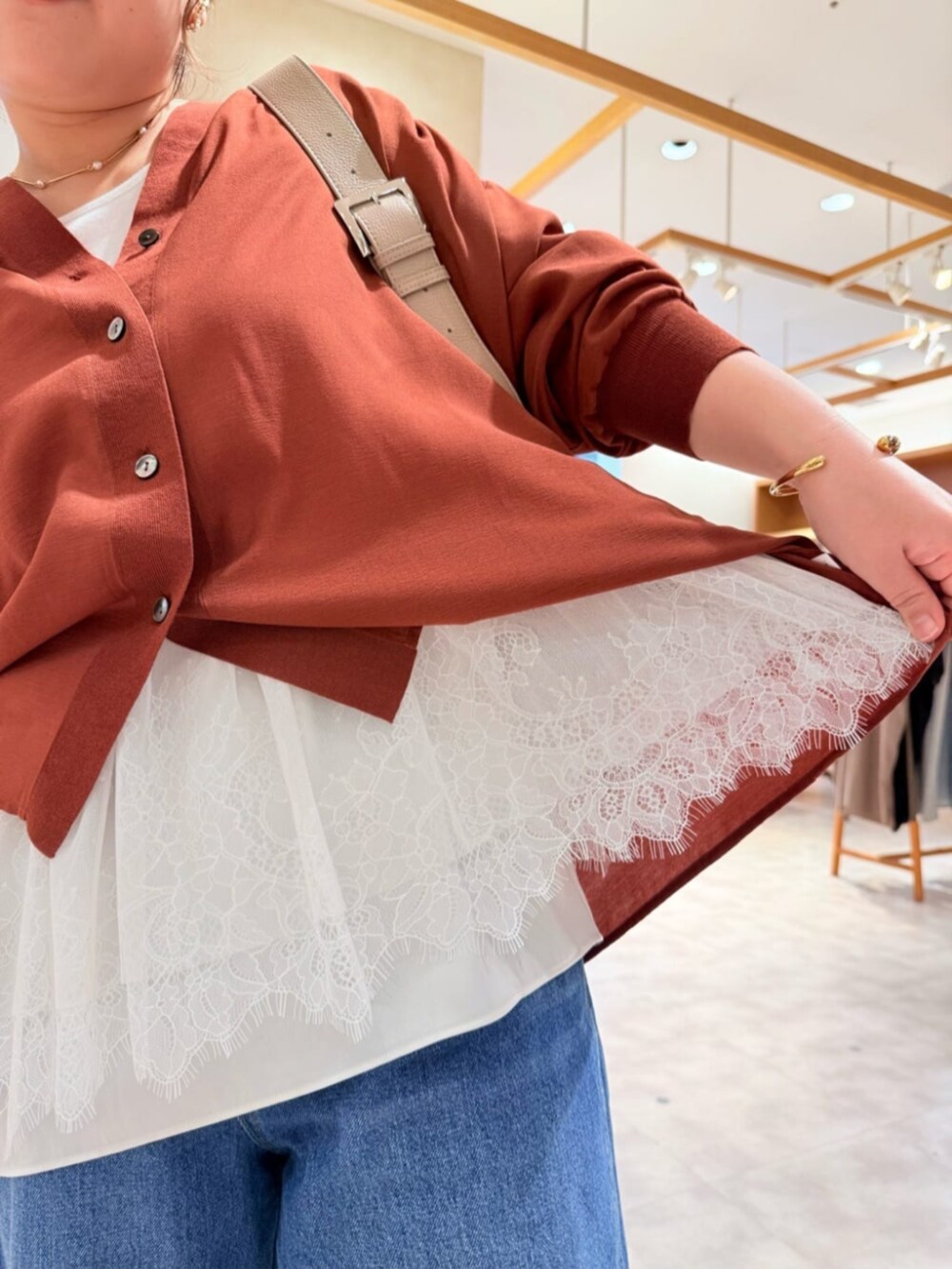ベージュ系のショルダーバッグ、ブルー系のその他パンツ、レッド系のシャツ/ブラウスを着用したレディースの春コーディネートの6枚目の写真