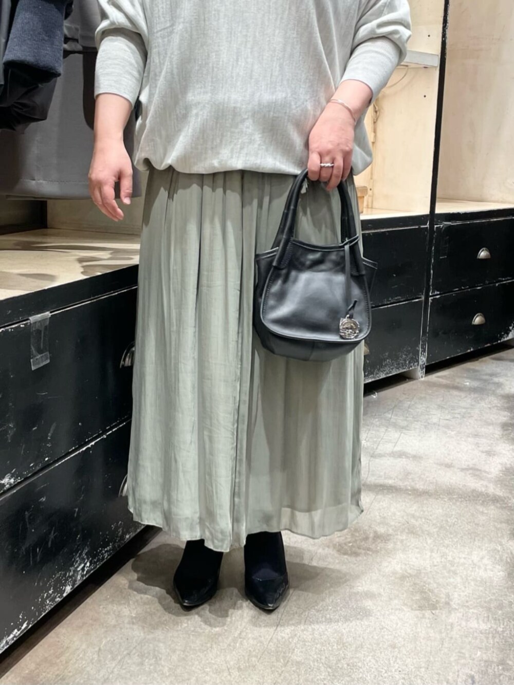 グレー系のニット/セーター、グリーン系のその他パンツ、ブラック系のトートバッグを着用したレディースの冬コーディネートの4枚目の写真