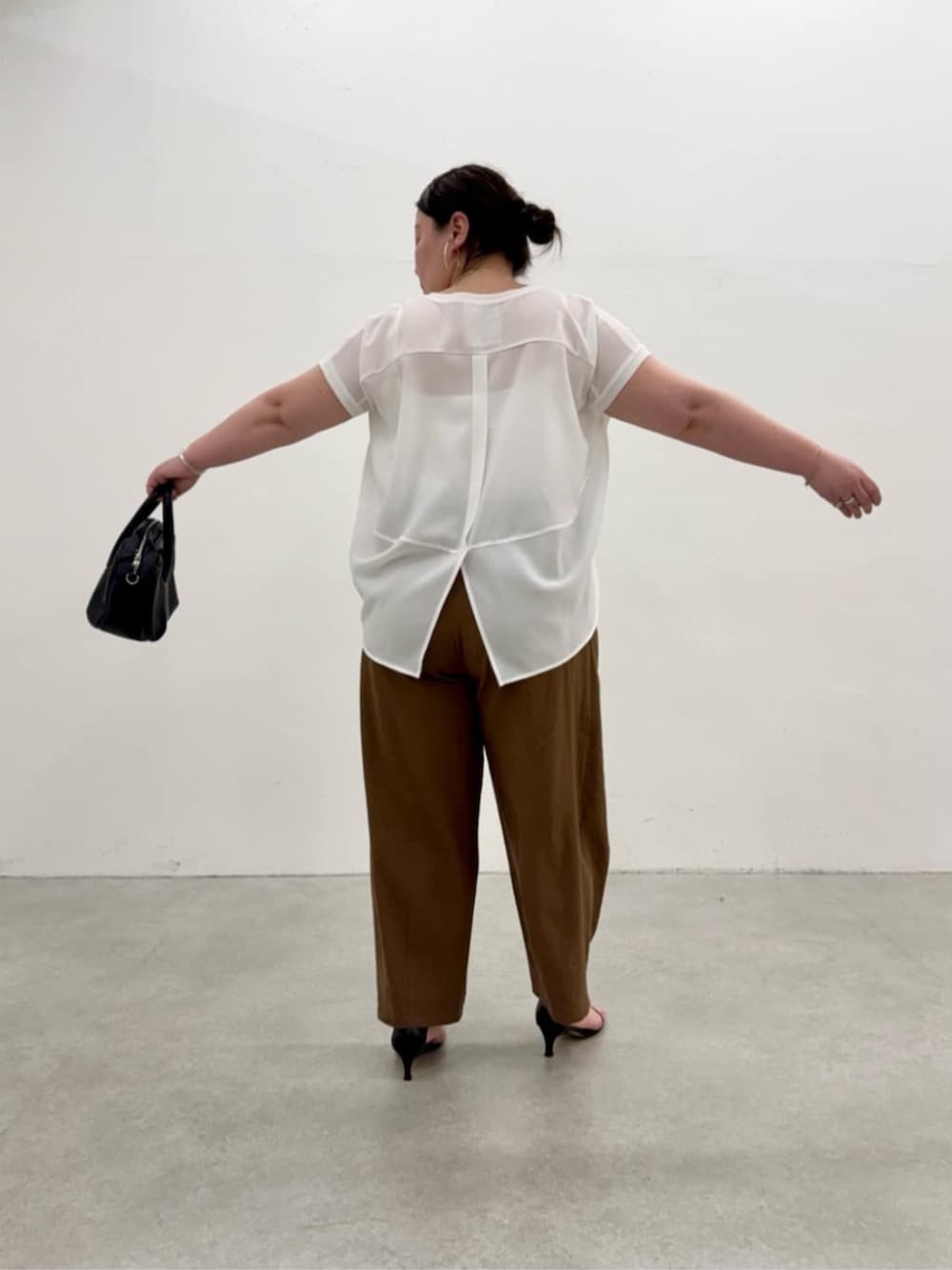 ブラック系のボストンバッグ、ホワイト系のシャツ/ブラウス、ブラウン系のその他パンツを着用したレディースの春コーディネートの8枚目の写真