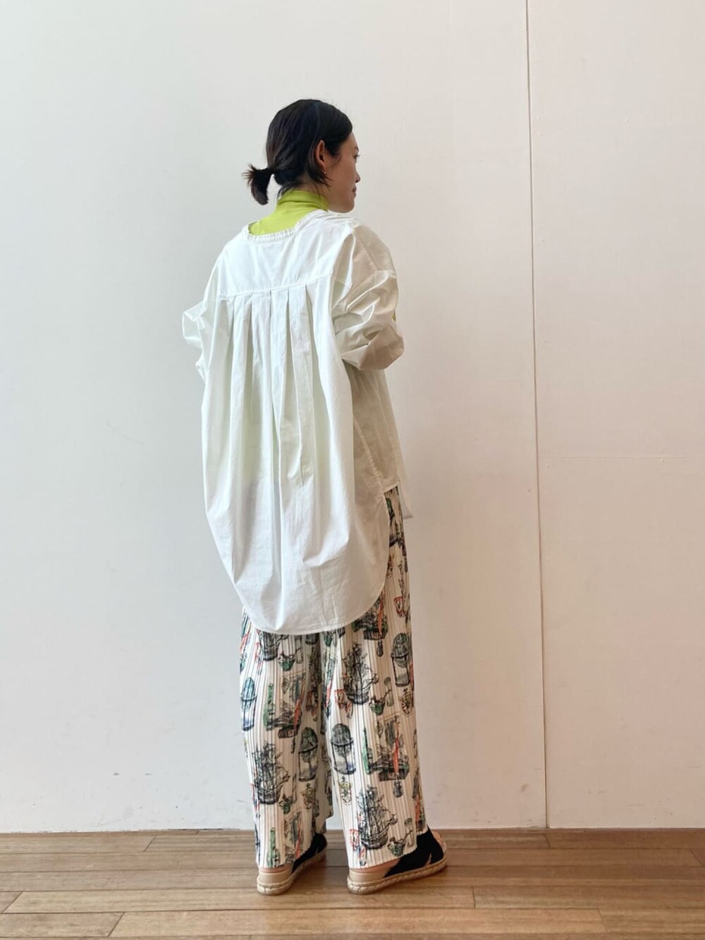 ベージュ系のその他パンツ、ホワイト系のシャツ/ブラウス、イエロー系のTシャツ/カットソーを着用したレディースの春コーディネートの3枚目の写真