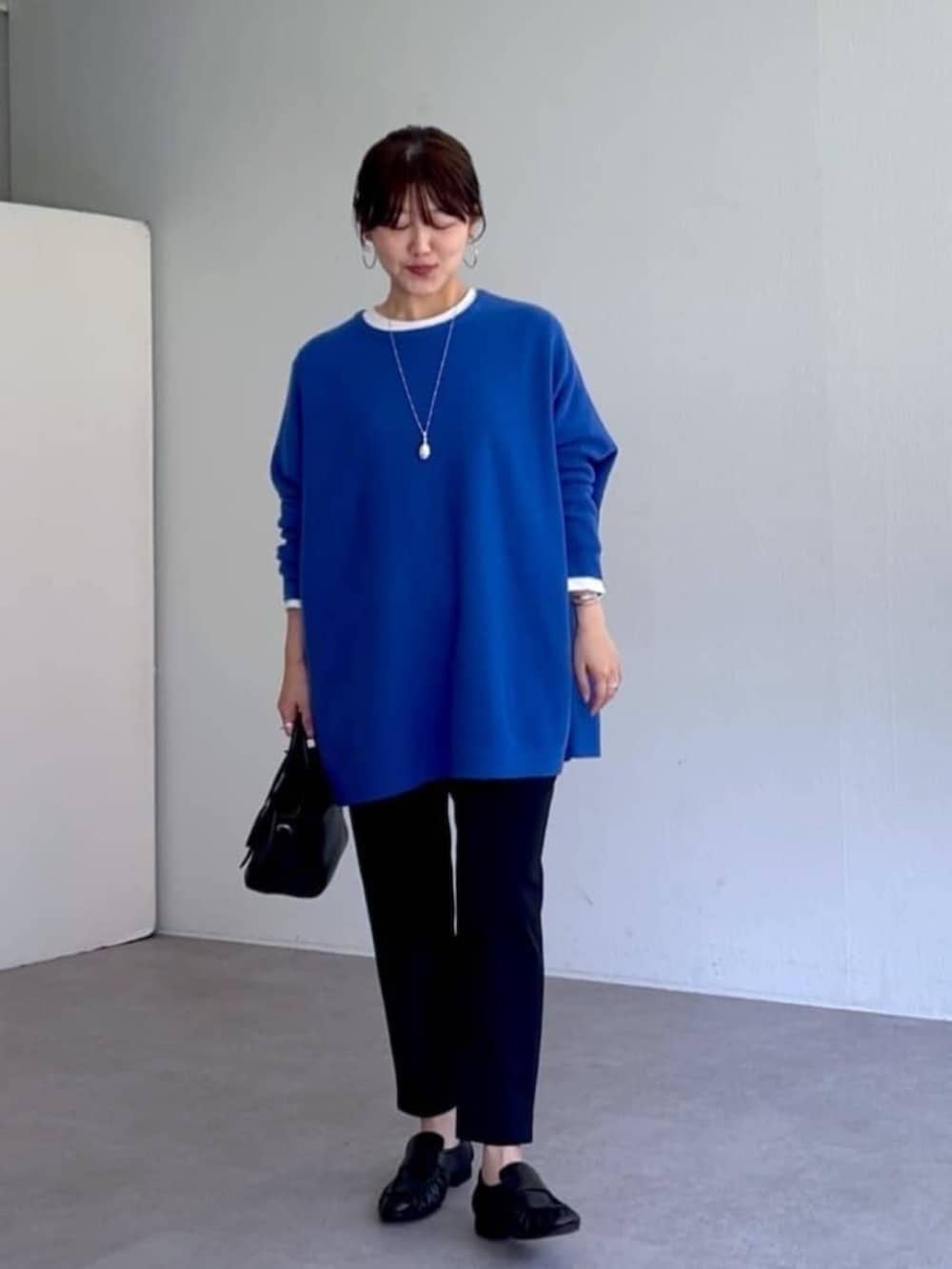 ブラック系のローファー、ブラック系のその他パンツ、ブルー系のニット/セーターを着用したレディースの秋コーディネートの2枚目の写真