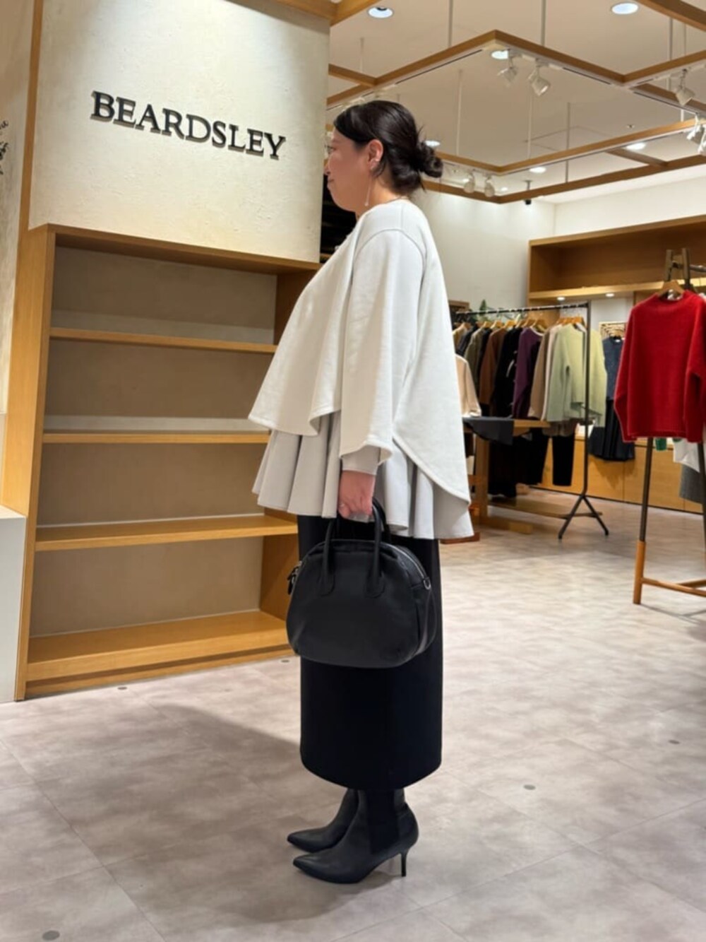 ブラック系のブーツ、ブラック系のスカート、ホワイト系のTシャツ/カットソーを着用したレディースの冬コーディネートの3枚目の写真