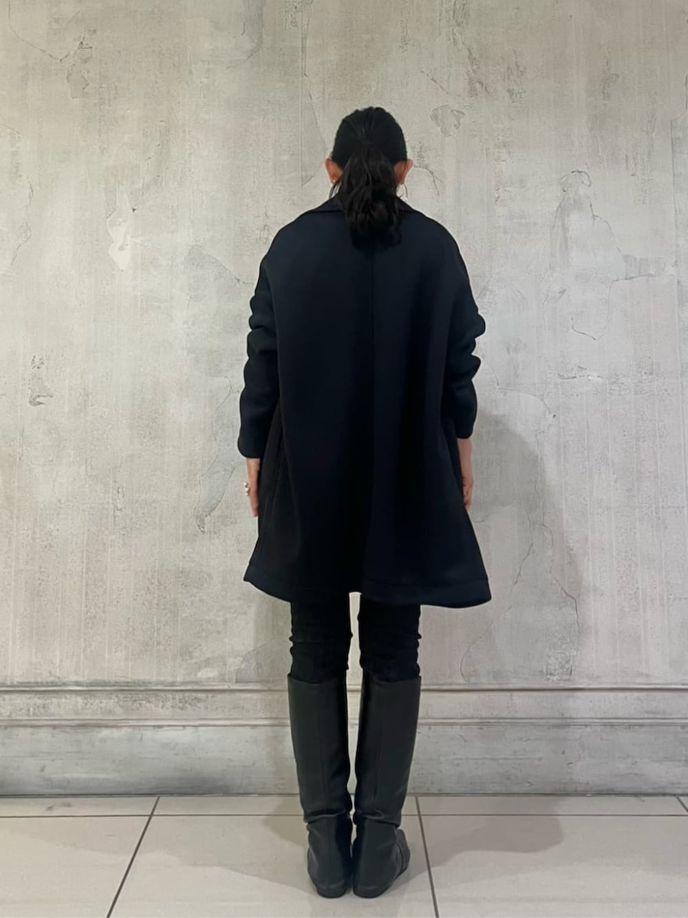 ブルー系のTシャツ/カットソー、ブラック系のデニムパンツ、ブラック系のピーコートを着用したレディースの冬コーディネートの9枚目の写真