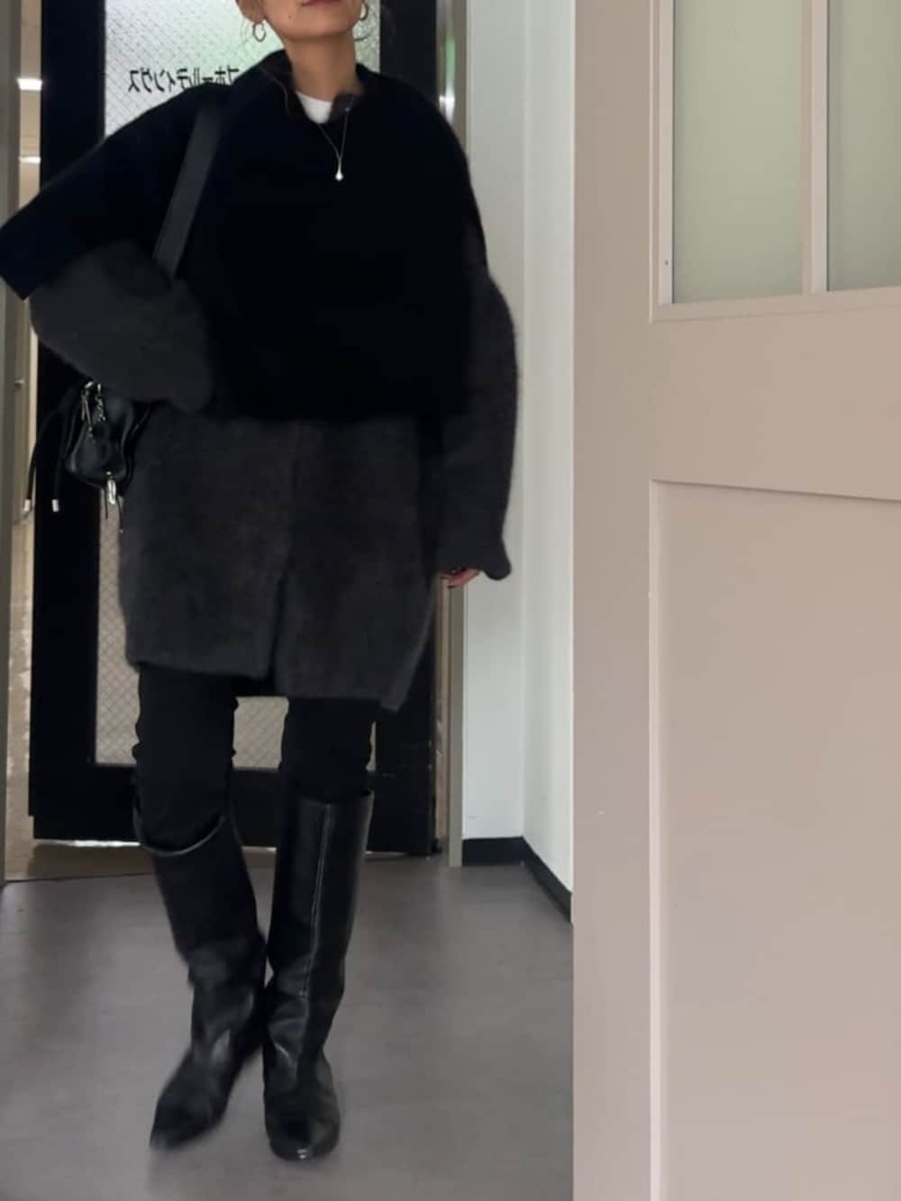 ブラック系のその他パンツ、ブラック系のニット/セーター、グレー系のその他アウターを着用したレディースの夏コーディネートの2枚目の写真