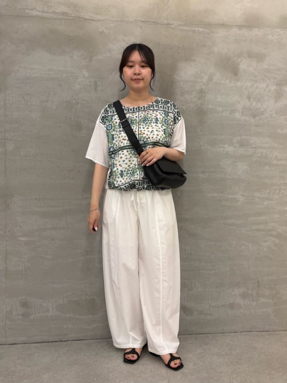 ブラック系のショルダーバッグ、ホワイト系のTシャツ/カットソーを着用したレディースの春コーディネートの2枚目の写真