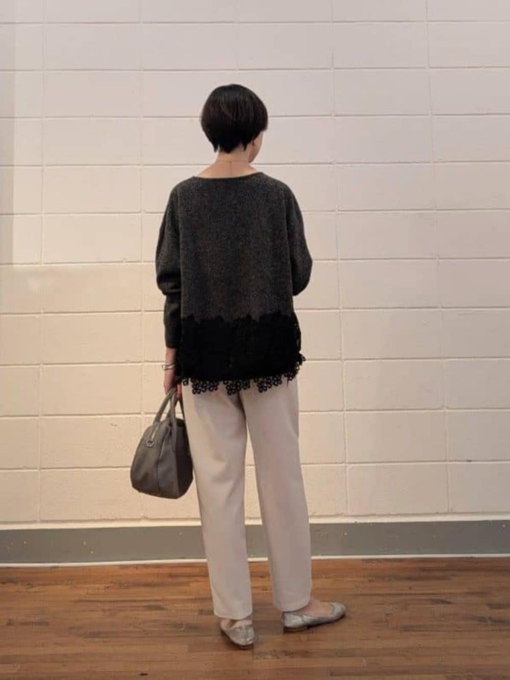 グレー系のトートバッグ、グレー系のニット/セーター、ホワイト系のその他パンツを着用したレディースの秋コーディネートの4枚目の写真
